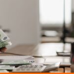 Eurobankjegyek, számológép és papírok az asztalon — a bérpapír kiszámolása